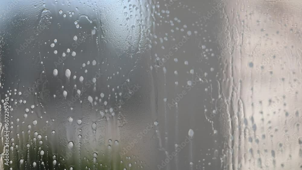 Liquid for washing glasses. Washing windows. The person splashes glass cleaner on the window and wipes the window with a microfiber cloth. Horizontal video.