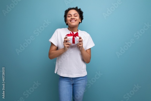 young hispanic woman in white t-shirt received a birthday present. holiday concept