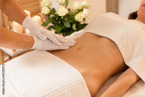   Woman receiving a belly massage at spa salon