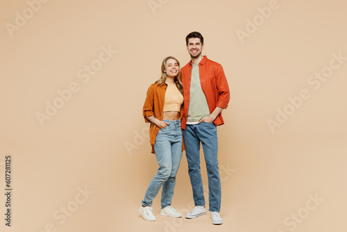 Full body smiling happy cheerful fun cool young couple two friends family man woman wear casual clothes together looking camera hugging isolated on pastel plain beige color background studio portrait.