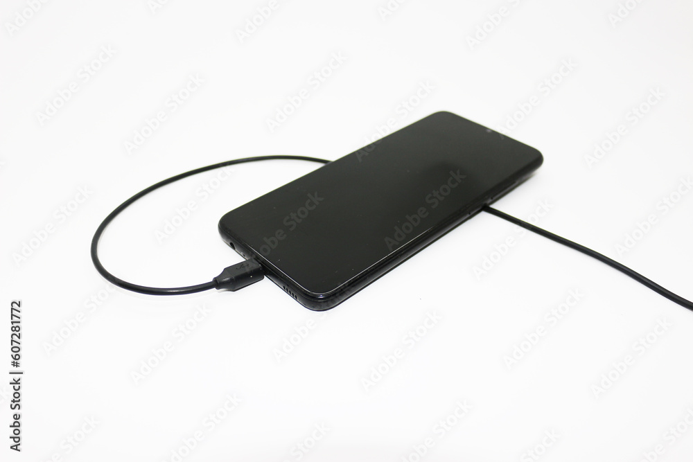 Black mobile phone being charged Black mobile phone being charged