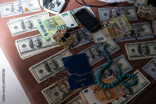 Police handcuffs lies on a set of green monetary denominations of 100 euros. A lot of money forms an infinite heap