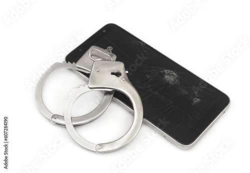 Handcuffs and smartphone with broken screen isolated on white background. Cyber crime and punishing concept.