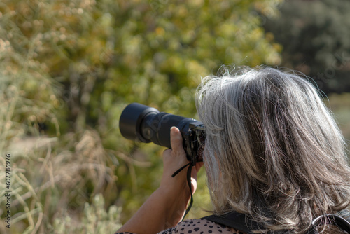 woman photographer seen from the back taking pictures in nature