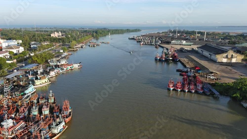 Aerial shot commercial ocean fishing boat floating on the river back to the harbour at morning time 