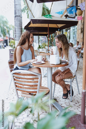 young latin woman drinking coffee with female friend at restaurant in Mexico Latin America, hispanic people in caribbean city