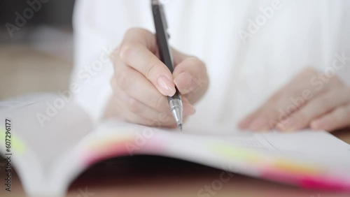 テキストを使って勉強する女性の手元
