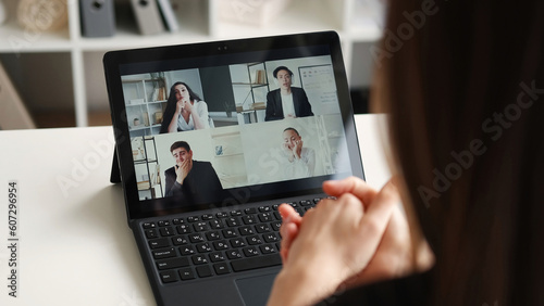 Online conference. Internet meeting. Remote discussion. Female manager watching freelance teamwork job consideration of project on video call on laptop at home office workplace.