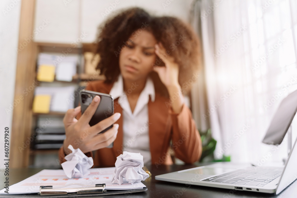 Young sad businesswoman is sitting at table, covering his face with his hand and talking on cell phone. On desk is laptop, tablet computer, Stress. Young sad businesswoman is sitting at table, covering his face with his hand and talking on cell phone. On desk is laptop, tablet computer, Stress.