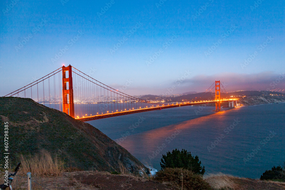Fototapeta premium cars at golden gate bridge in the evening under blue sky