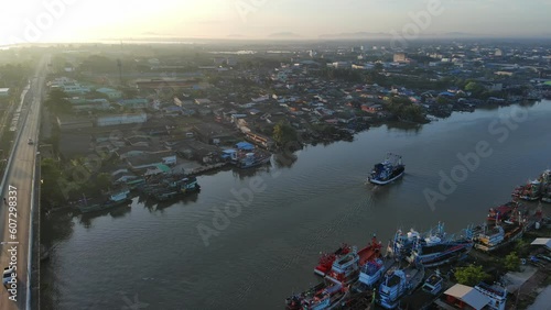Aerial shot commercial ocean fishing boat floating on the river back to the harbour at morning time 