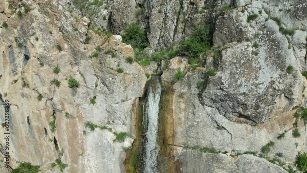 Waterfall flowing high over rocks. thin stream of water flowing into the valley. Taken with a drone 60Fps 4K video Waterfall flowing high over rocks. thin stream of water flowing into the valley. Taken with a drone 60Fps 4K video