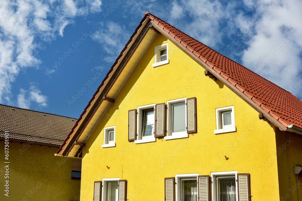 Frisch renovierte Fassade eines älteren Gebäudes mit Fensterläden