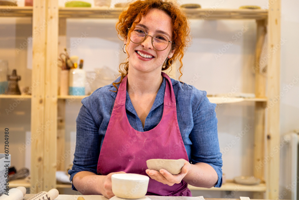 Woman working in pottery studio workshop making bowl from clay. Woman working in pottery studio workshop making bowl from clay.