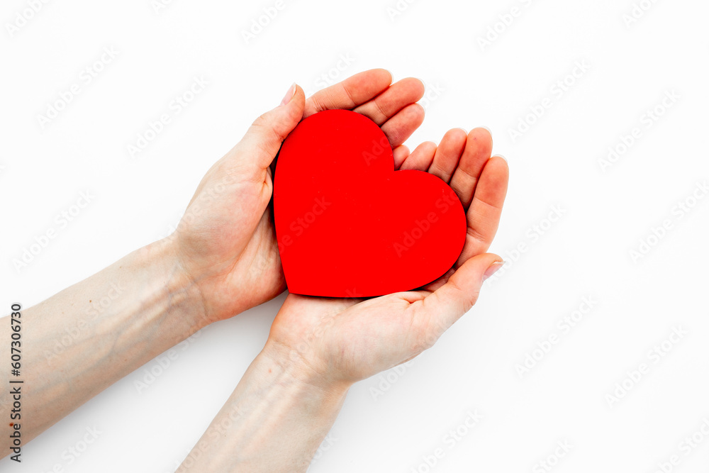 Red heart with woman hands, top view. Health care and love concept