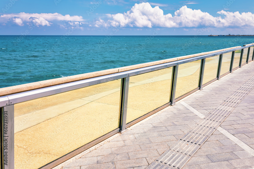 Seaside with glass balustrade . Sidewalk on the sea shore