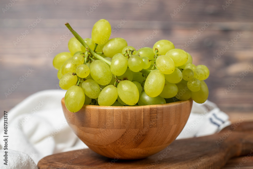 Green grapes in bowl. Organic farm products. Fresh bunch of grapes on wooden background. Close up Green grapes in bowl. Organic farm products. Fresh bunch of grapes on wooden background. Close up