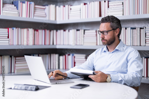 Portrait of serious business man in library. Handsome business man in office. Business man giving classes. Office business.