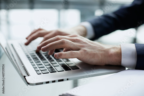 Closeup image of a man working and typing on laptop computer keyboard