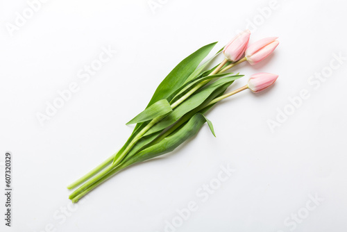 Bouquet of pink tulips on colored table background . Top view with copy space. Waiting for spring. Happy Easter card. Flat lay