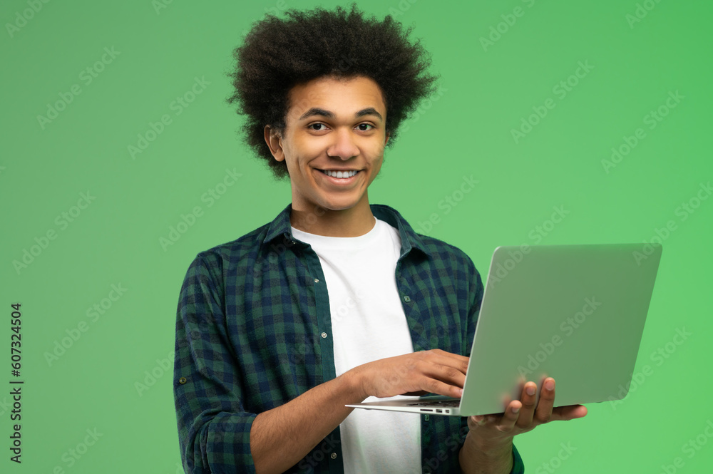 Young african american guy in checkered shirt with a laptop Young african american guy in checkered shirt with a laptop