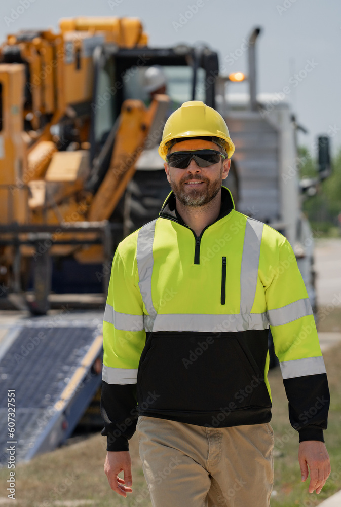 Machinery builder at buildings background. Excavator loader tractor and buider worker. Portrait of worker man small business owner. Construction worker with hardhat helmet on construction site. Machinery builder at buildings background. Excavator loader tractor and buider worker. Portrait of worker man small business owner. Construction worker with hardhat helmet on construction site.