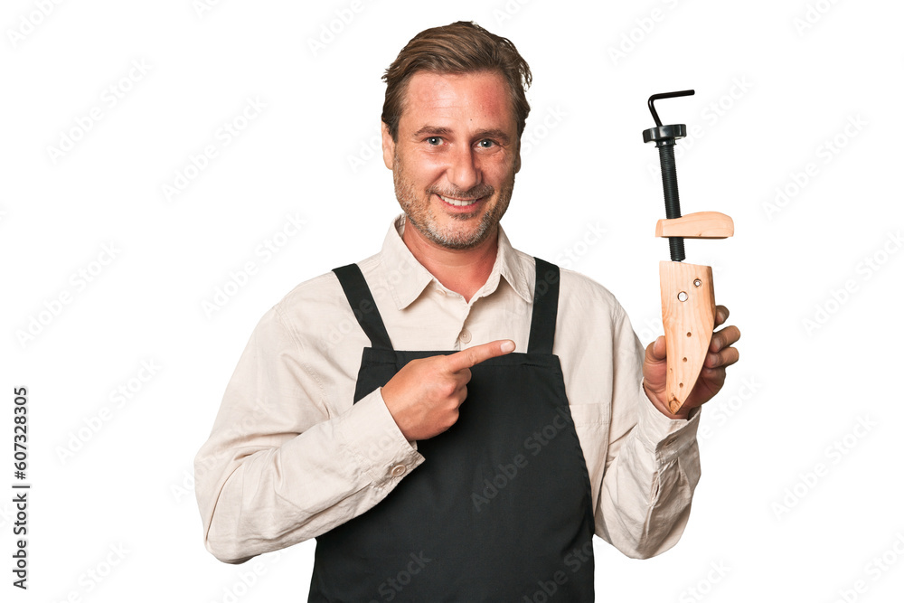 A middle-aged shoe maker smiling and pointing aside, showing something at blank space. A middle-aged shoe maker smiling and pointing aside, showing something at blank space.