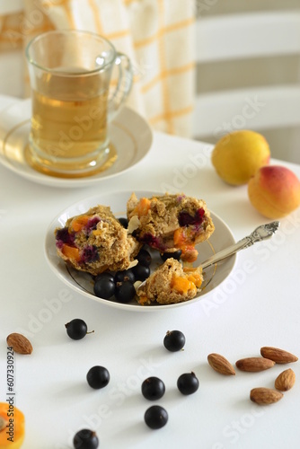 Muffins with apricots and black currants sprinkled with almond flakes