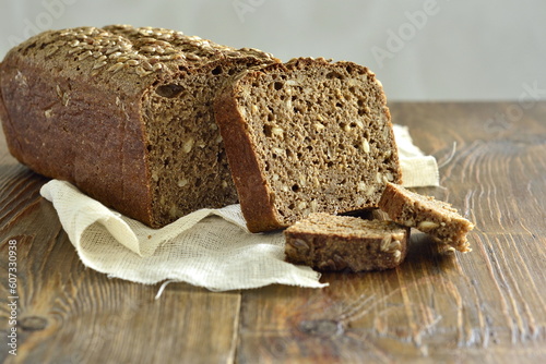 Homemade sourdough rye bread with sunflower seeds on rustic wooden background. Healthy nutrition