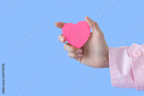 Heart in Doctor's hands on blue background. A Doctor's hand protecting and reassures patient.Healthcare and hospital medical. Organ donation,charity,cardiologist,heart care .Valentine day.copy space.