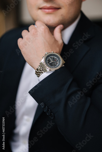 Close-up photo of man put hand on chin. Luxury watch on man's hand. Stylish look
