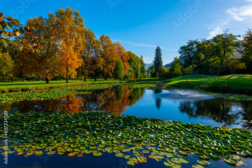 Golf Course with Water Pond and Autumn Trees in a Sunny Day in Lugano, Ticino, Switzerland.