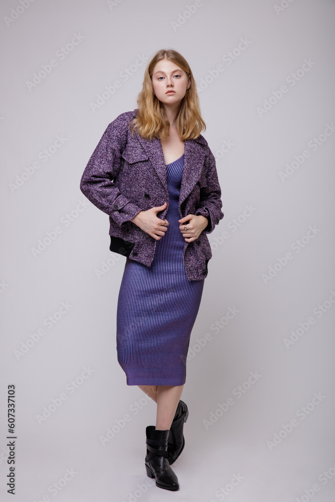 Fashion photo of a beautiful elegant young woman in a pretty blue dress, jacket posing on white, soft gray background. Studio Shot, portrait. Slim figure. Blonde Fashion photo of a beautiful elegant young woman in a pretty blue dress, jacket posing on white, soft gray background. Studio Shot, portrait. Slim figure. Blonde
