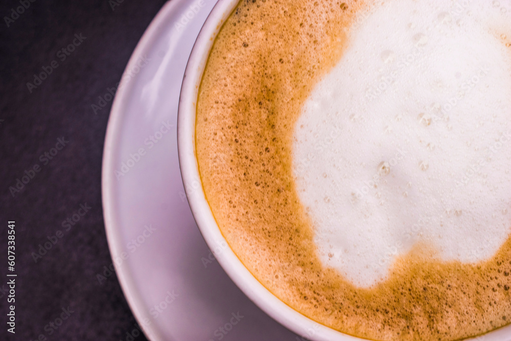 Hot Cappuccino with white cup on black wood table, top view Hot Cappuccino with white cup on black wood table, top view