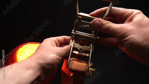 ratchet lashing straps orange operating principle in human hands  photo