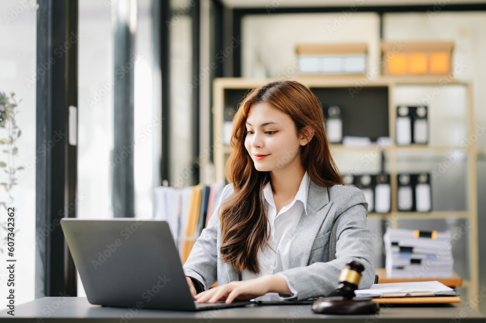 Beautiful Asian woman using laptop and tablet while sitting at her working place. Concentrated at office Beautiful Asian woman using laptop and tablet while sitting at her working place. Concentrated at office