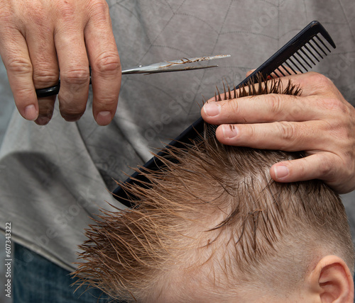 men's haircut with scissors and clipper in the salon
