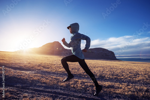 Woman trail runner cross country running in sunset