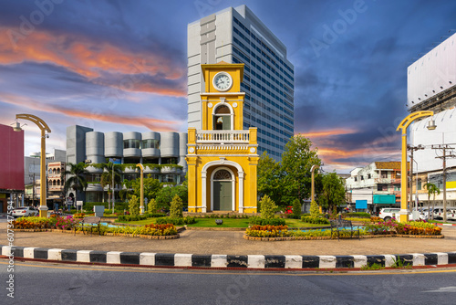 Clock tower on a roundabout in old phuket town at during the summer day surrounded by high-rise buildings and Hotels in phuket thailand. 