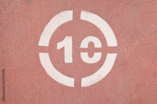 Number 10 sign on a red asphalt.