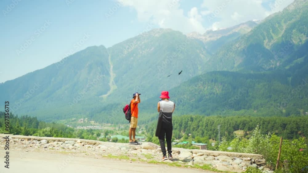 Slow motion of two South Asians taking photos in Gulmarg valley, India