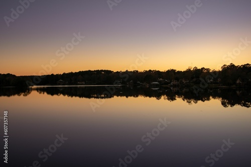 Breathtaking view of a river with the reflection of the houses on the coast at scenic sunset © Brandon Garner/Wirestock Creators