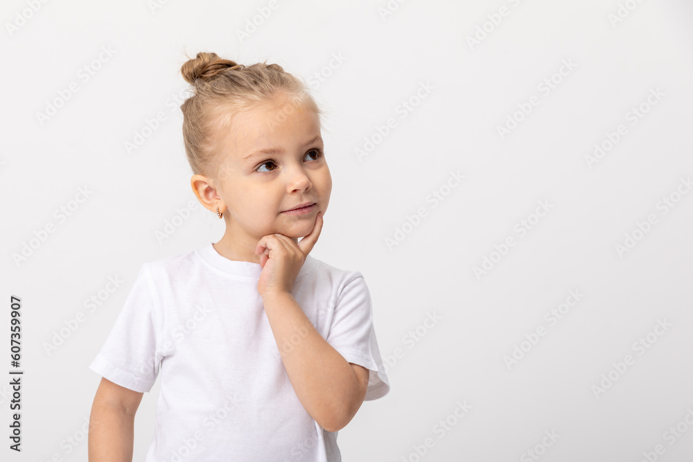 Little fun cute kid girl 4-5 years old wears white t-shirt prop up on chin think dream isolated on white background child studio portrait. Mother's Day love family people lifestyle concept Little fun cute kid girl 4-5 years old wears white t-shirt prop up on chin think dream isolated on white background child studio portrait. Mother's Day love family people lifestyle concept