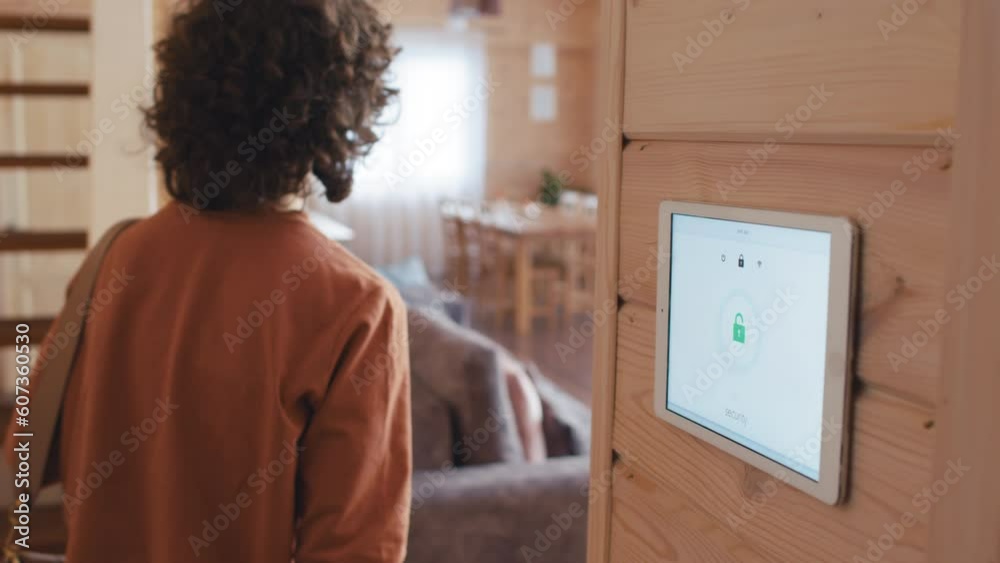 Selective focus shot of Caucasian woman with curly hair unlocking smart home system after coming back home Selective focus shot of Caucasian woman with curly hair unlocking smart home system after coming back home