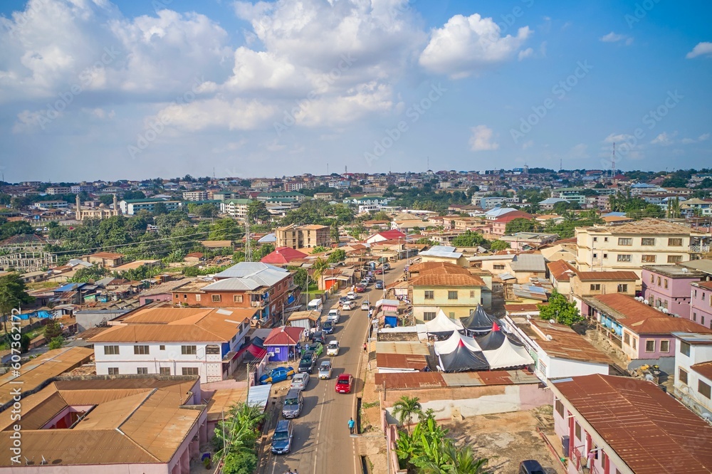 Aerial view of a small village filled with buildings and a road with cars in Kumasi, Ghana