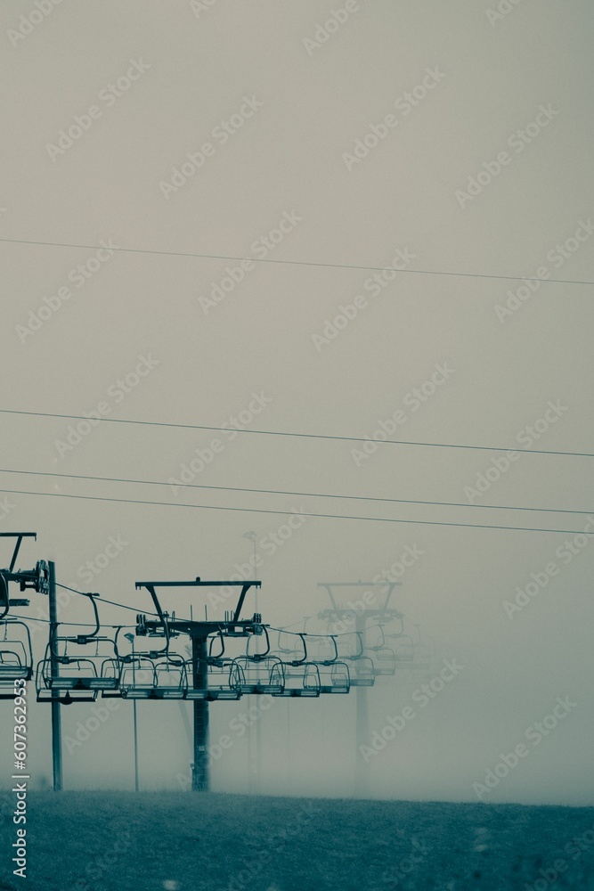 Vertical shot of ropeway covered by fog