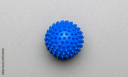 Close-up top view of a spikey blue massage ball over the gray surface photo