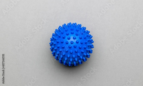 Close-up top view of a spikey blue massage ball over the gray surface