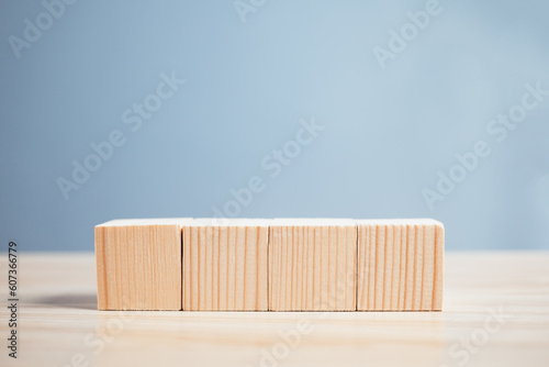 Fototapeta Naklejka Na Ścianę i Meble -  wood empty four blocks on table and blue background with copy space for text or symbols, development concept for growth success process.