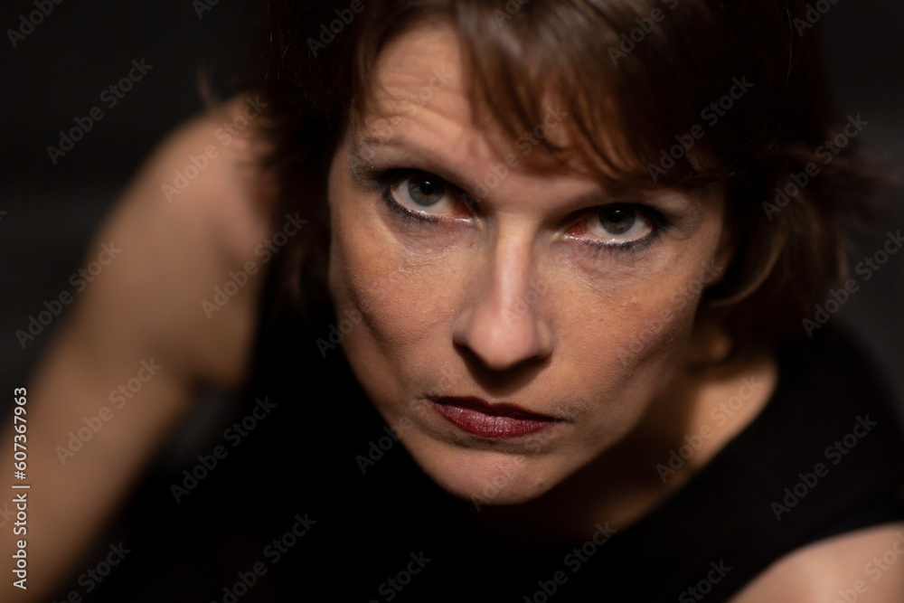 Close-up, Nahaufnahme Porträt einer schönen Frau mit langen brünette Haaren im Studio vor schwarzen Hintergrund 